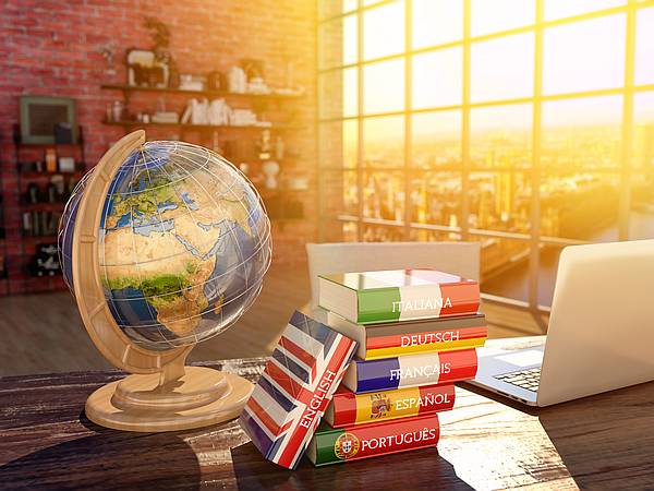 A classroom showing a globe, language books and a laptop